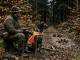 Jagdhund und Jäger im Wald nahe einer Schwarzwildfährte als Hinweis auf die Aujeszkysche Krankheit.