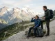 Zwei Wandernde machen bei Erschöpfung im Gelände eine sichere Pause auf einem alpinen Wanderweg.