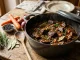 Ein Wildschweingulasch-Rezept im gusseisernen Schmortopf mit zarten Fleischwürfeln und dunkler Sauce.