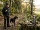 Jäger und Jagdhund auf einem Waldweg; saubere Handschuhe und eine Bürste stehen für das Fuchsbandwurm-Risiko und sorgfältige Revierhygiene.